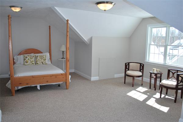 15 Littleton Road, Unit 2B Harvard, MA 01451 - Photo 20 of 29 a bedroom with a bed and a chandelier next to a window
