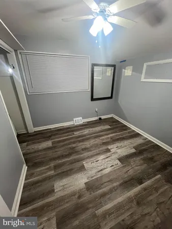 a view of a hallway with wooden floor and entryway