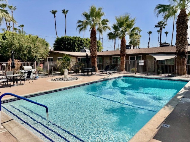 74402 Abronia, Unit 7 Palm Desert, CA 92260 - Photo 1 of 15 a view of a swimming pool with a patio and a yard