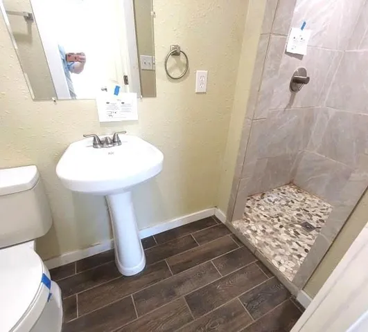 a bathroom with sink toilet and shower