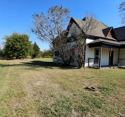 a view of a house with a yard and tree