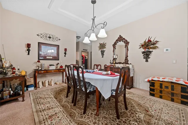 a view of a dining room with furniture and chandelier