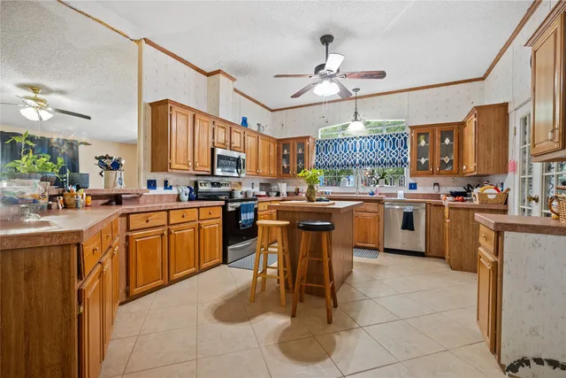 a kitchen with a sink a counter top space appliances and cabinets