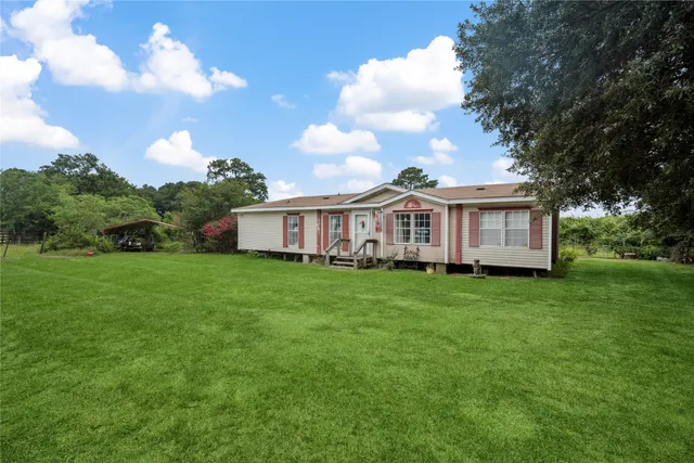 a view of a yard in front of a house with a large garden