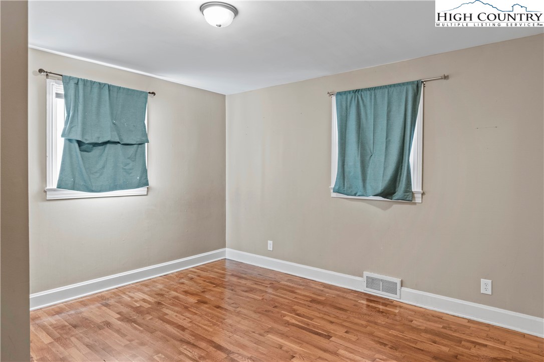 133 South Street Elkin, NC 28621 - Photo 11 of 24 a view of an empty room with wooden floor and a window