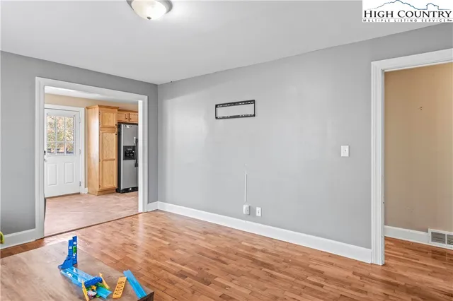 an empty room with wooden floor and natural light