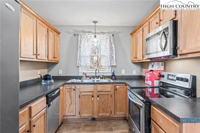 a kitchen with stainless steel appliances granite countertop a sink stove and cabinets