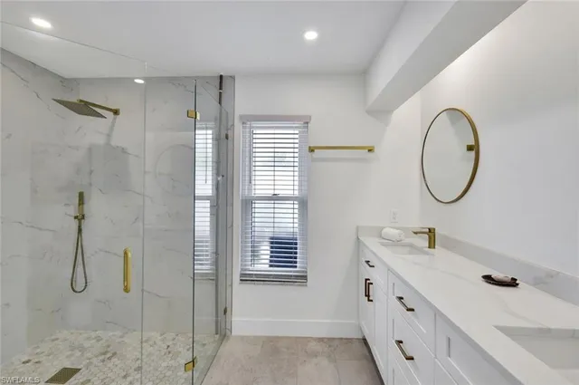 a bathroom with a double vanity sink mirror and shower