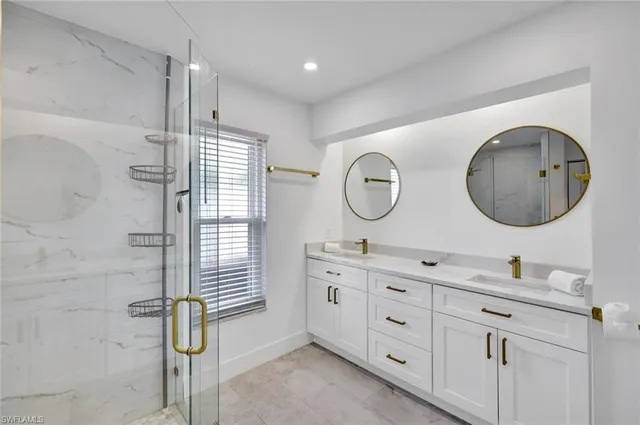 a bathroom with a double vanity sink mirror and bathtub
