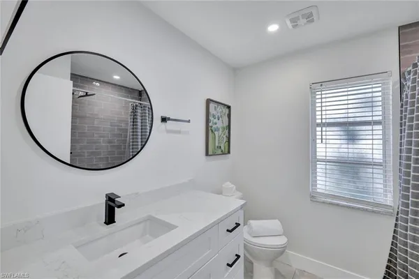 a bathroom with a sink a toilet and a mirror