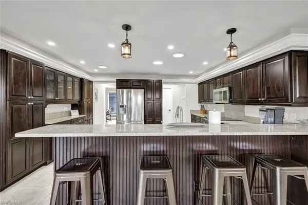 a kitchen with stainless steel appliances granite countertop a stove top oven a sink refrigerator and cabinets