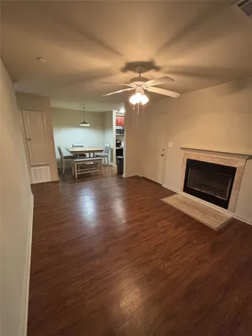 a view of a livingroom with wooden floor and a ceiling fan