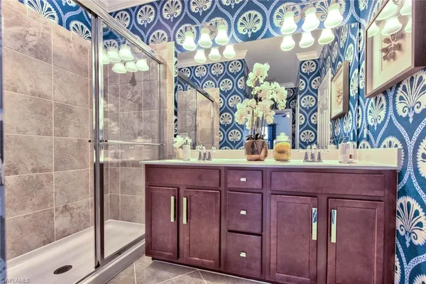 a spacious bedroom with a bed and a chandelier fan