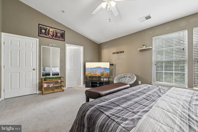 a bedroom with a bed and dresser with mirror