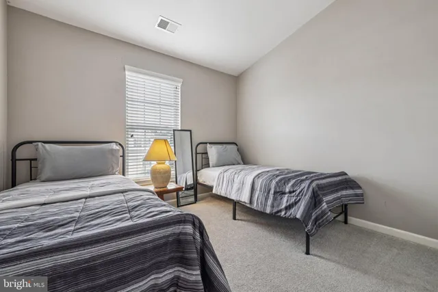 a bedroom with two beds and painting on the wall