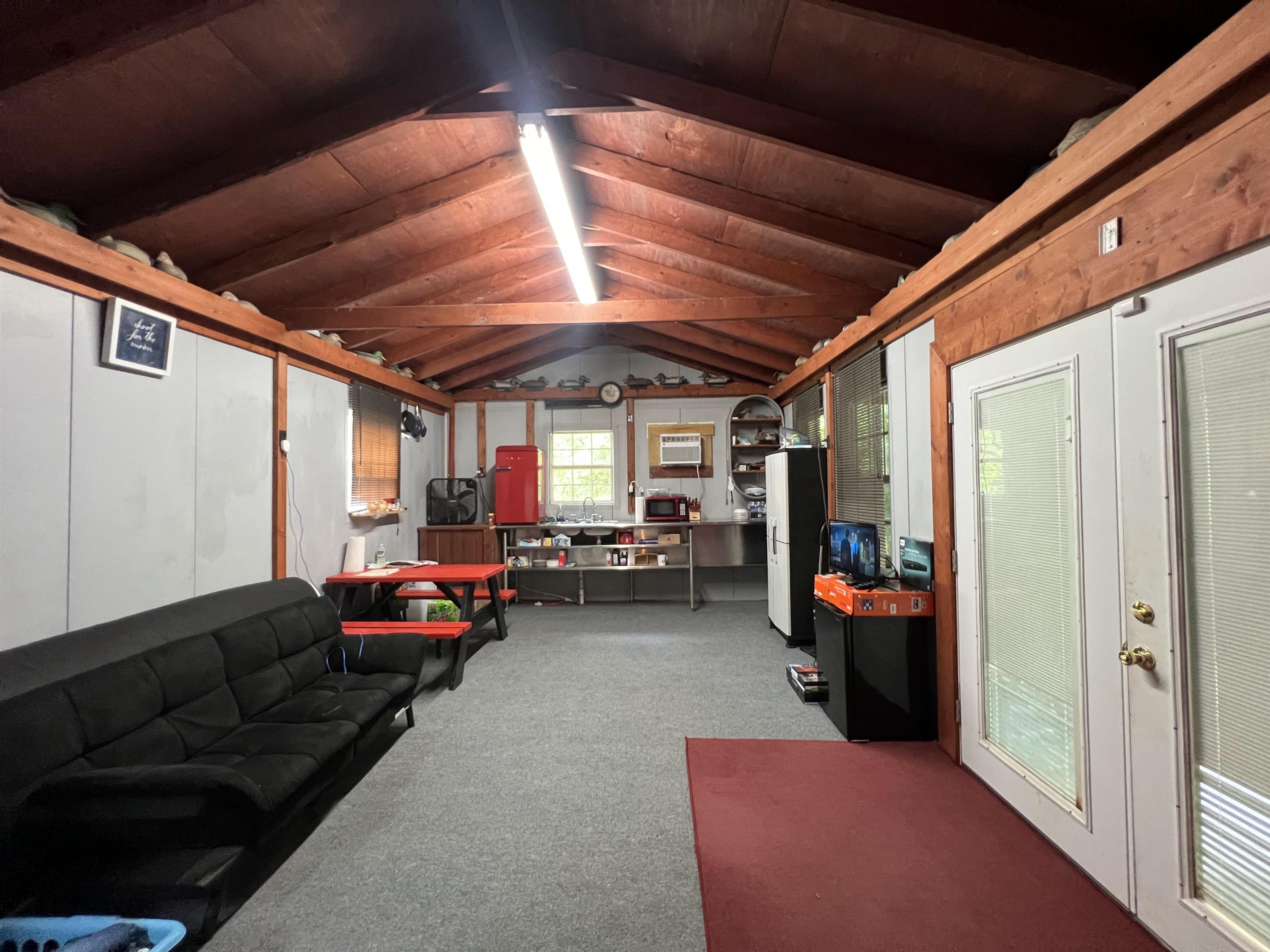 590 Towboat Lane Adamsville, TN 38310 - Photo 4 of 39 Carpeted living room with vaulted ceiling with beams and wooden ceiling