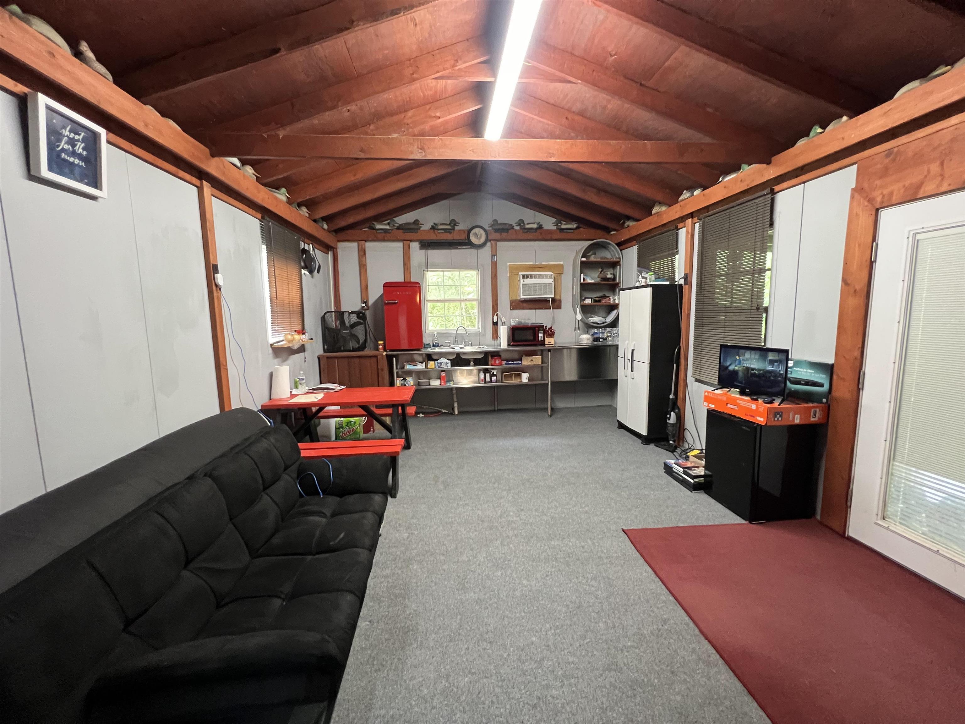 590 Towboat Lane Adamsville, TN 38310 - Photo 5 of 39 Living room with carpet flooring, lofted ceiling with beams, and wooden ceiling