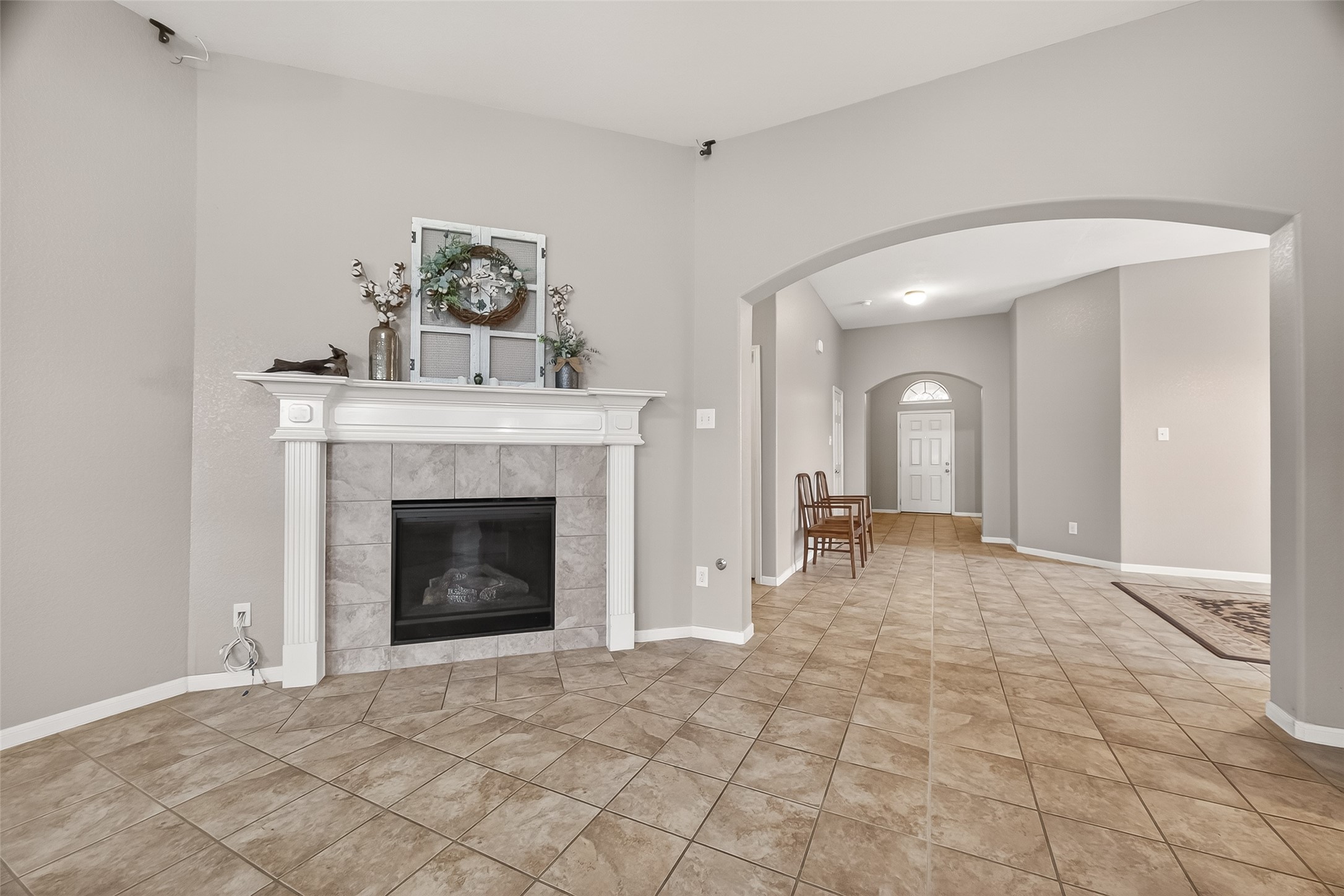 9110 Cavalier Lane Rosenberg, TX 77469 - Photo 10 of 30 The living room flows into an arched hallway leading to the dining room and front door, creating an inviting and open atmosphere.