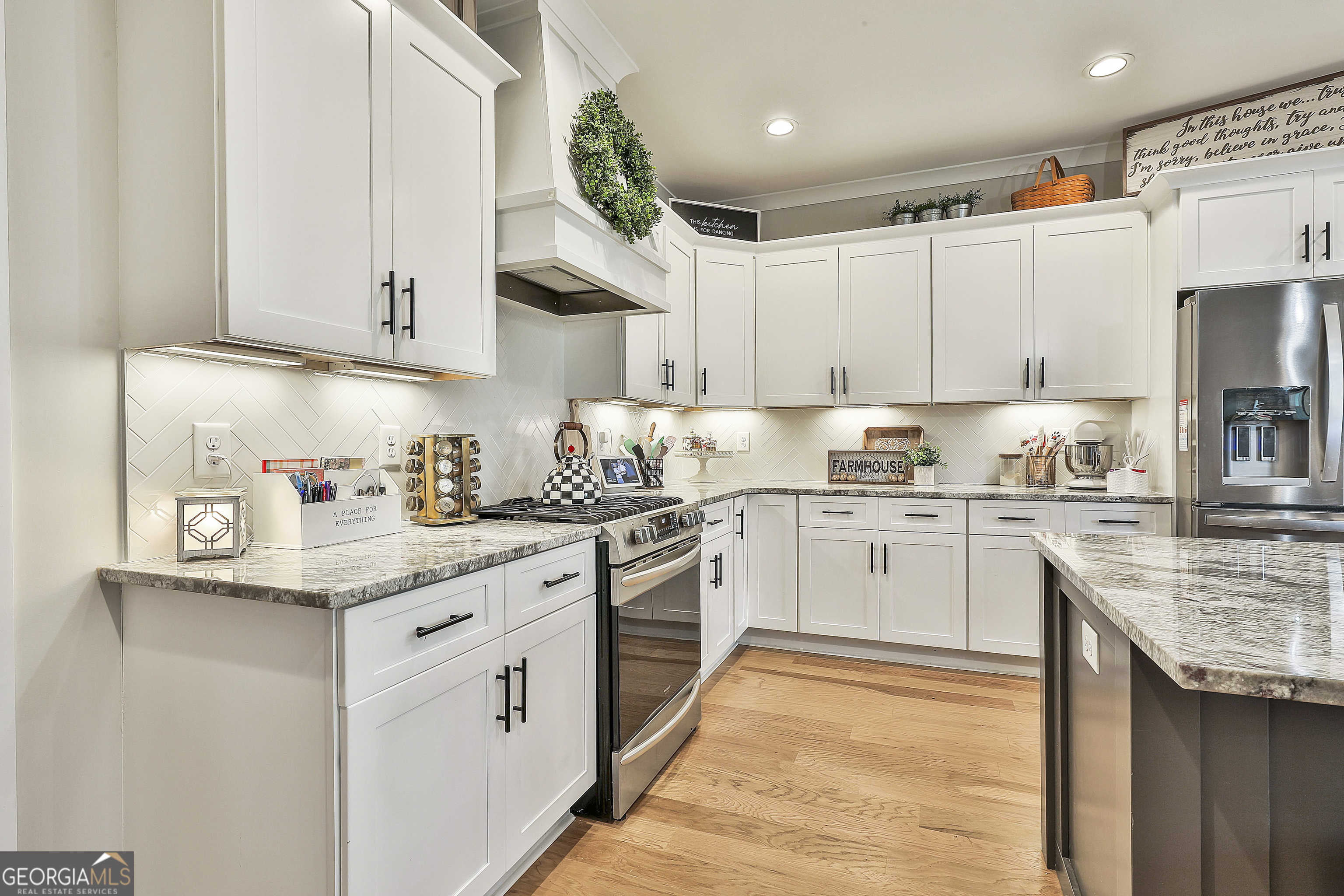 255 Werner Way Senoia, GA 30276 - Photo 19 of 47 a kitchen with granite countertop white cabinets and white appliances