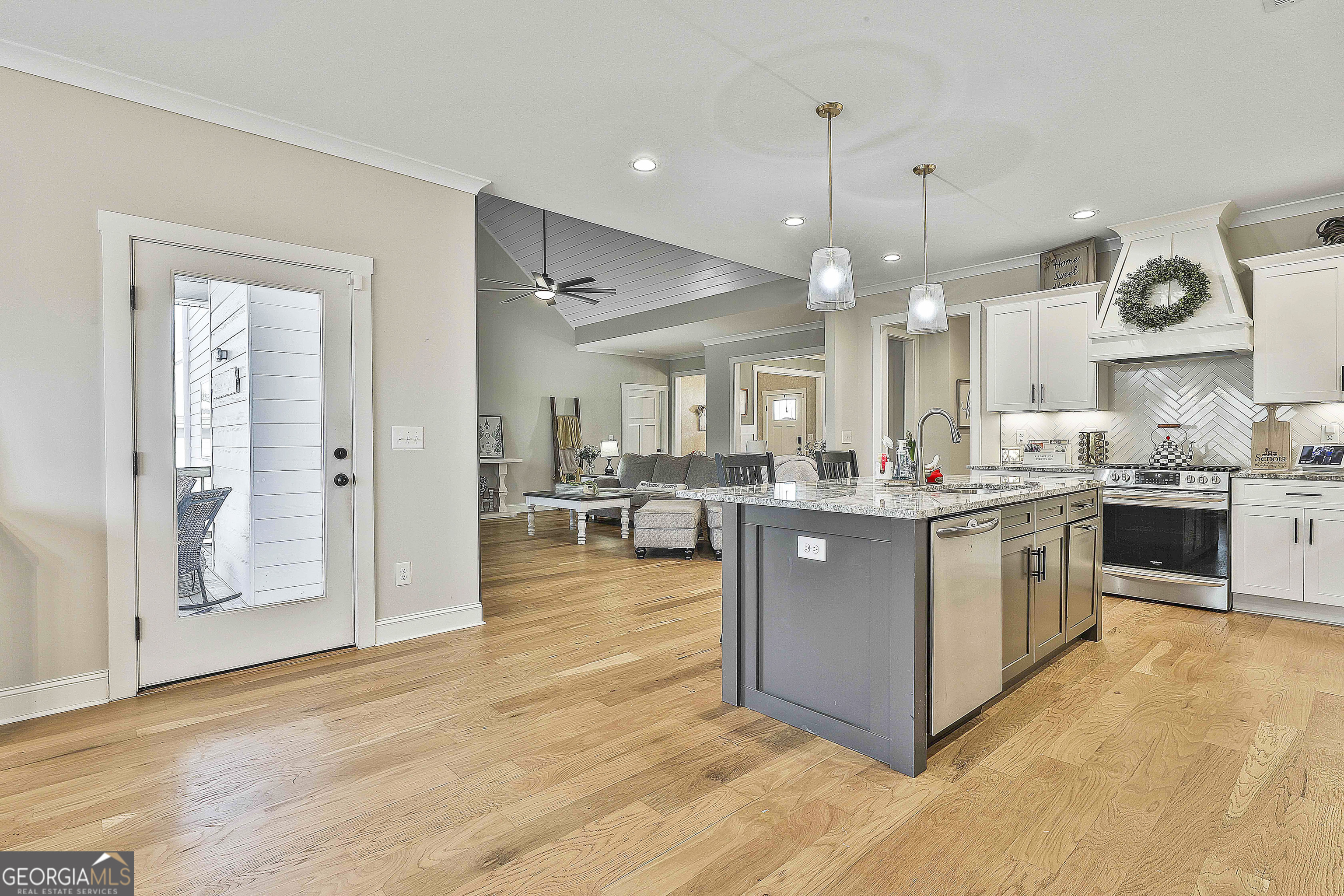 255 Werner Way Senoia, GA 30276 - Photo 25 of 47 a kitchen with stainless steel appliances granite countertop a large center island a stove a refrigerator and a view of living room