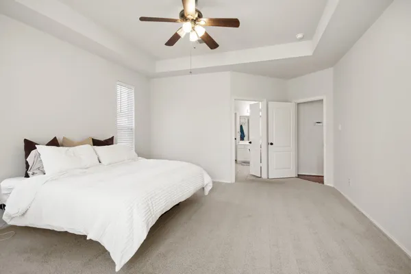 a spacious bedroom with a bed and a chandelier
