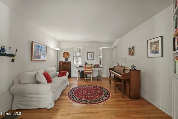 a bedroom with a bed and a chair with the wooden floor