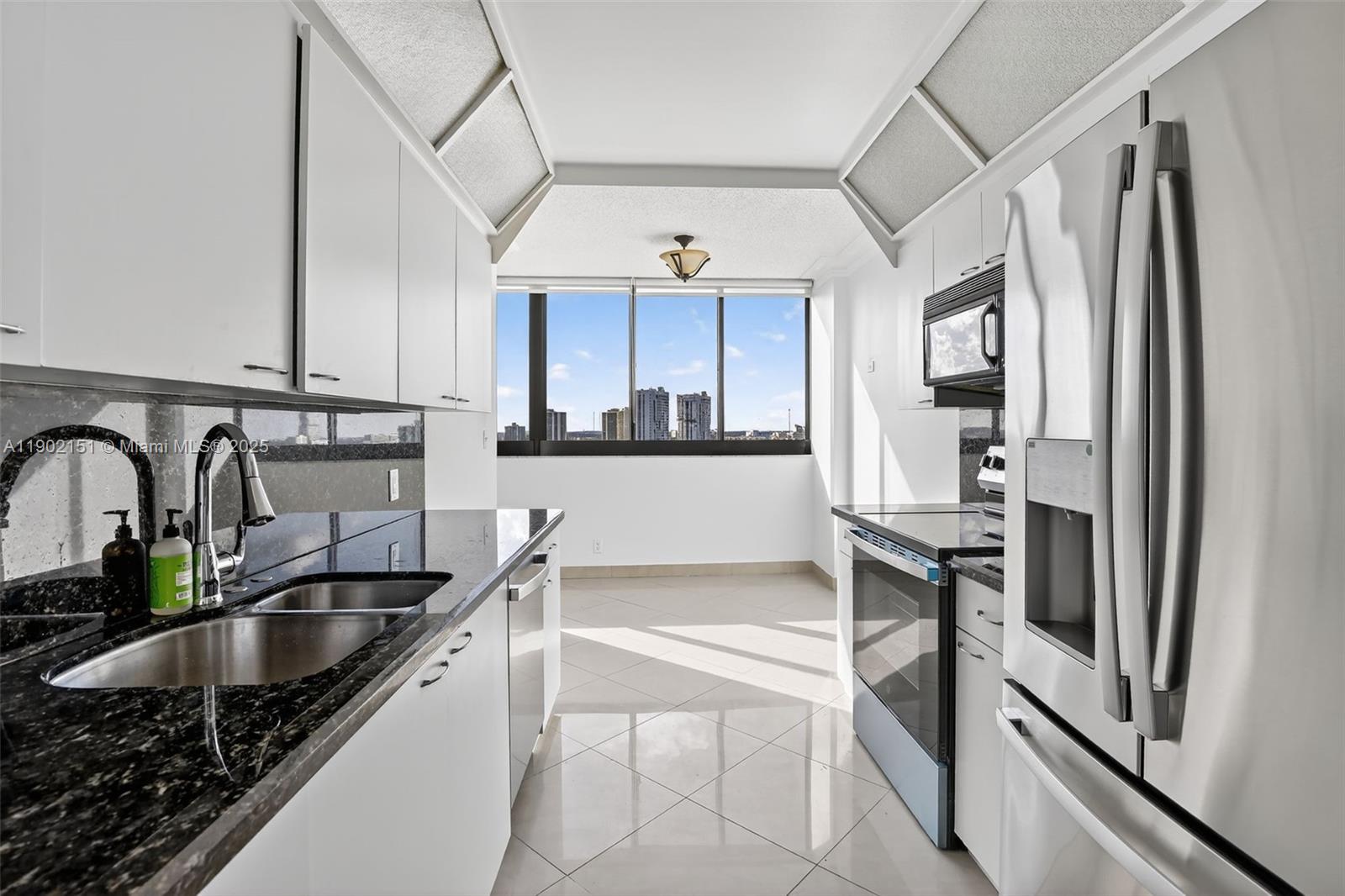 20185 East Country Club Drive, Unit 1405 Aventura, FL 33180 - Photo 17 of 67 a kitchen with stainless steel appliances granite countertop a sink stove and refrigerator