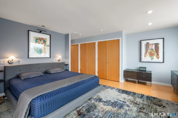 a bedroom with a bed and dresser with chair