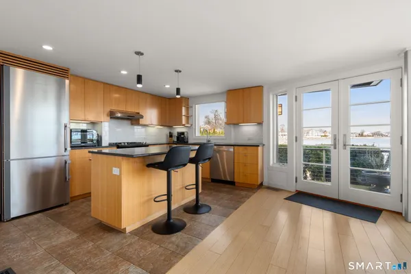 a kitchen with stainless steel appliances granite countertop a refrigerator and a stove top oven