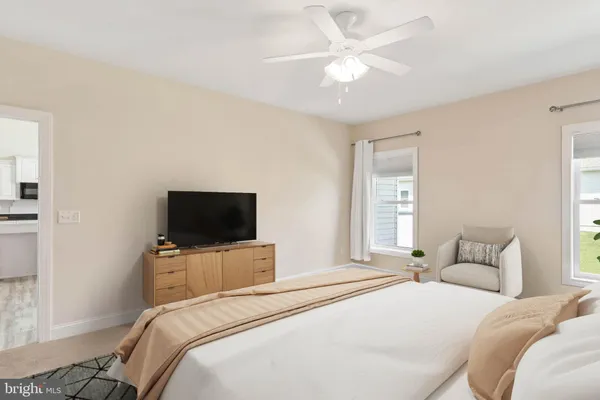 a bedroom with a bed window and a flat screen tv