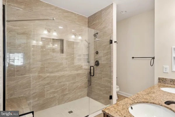 a bathroom with a granite countertop sink a shower and a mirror