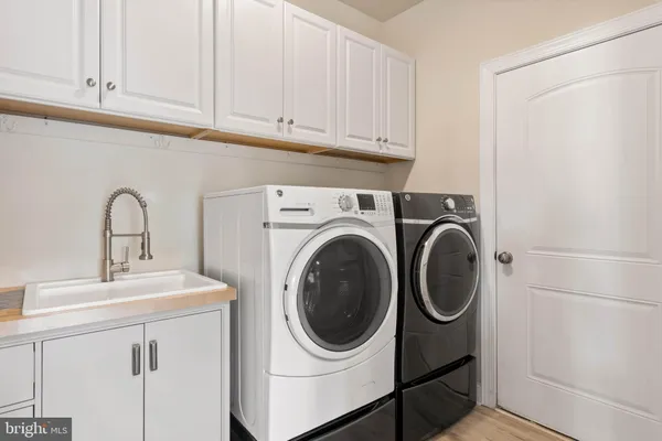 a utility room with sink dryer and washer