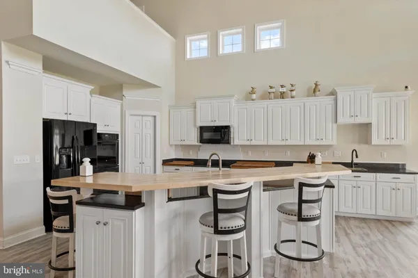 a kitchen with a sink a stove a refrigerator and white cabinets
