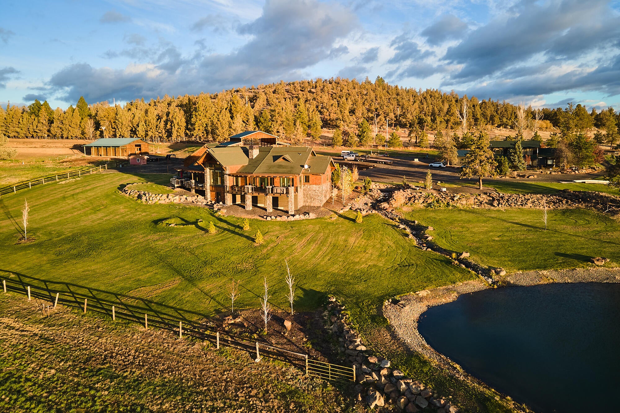 Aerial of main home and landscaped yard/pond.