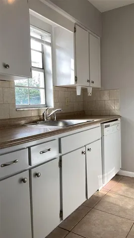 a kitchen with granite countertop cabinets and refrigerator
