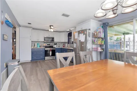 a kitchen with stainless steel appliances kitchen island granite countertop a refrigerator and microwave