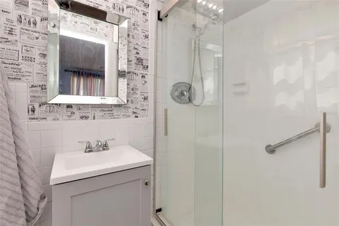 a bathroom with a sink mirror and shower
