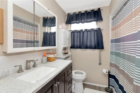 a bathroom with a sink a toilet and shower curtain