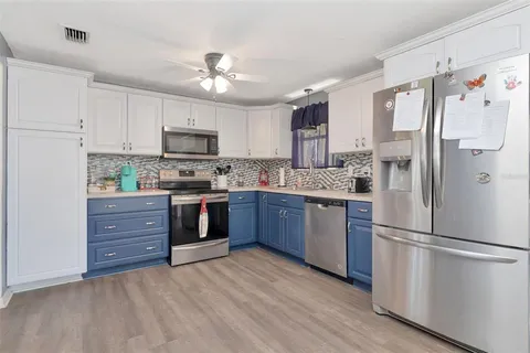 a kitchen with a refrigerator and a stove top oven