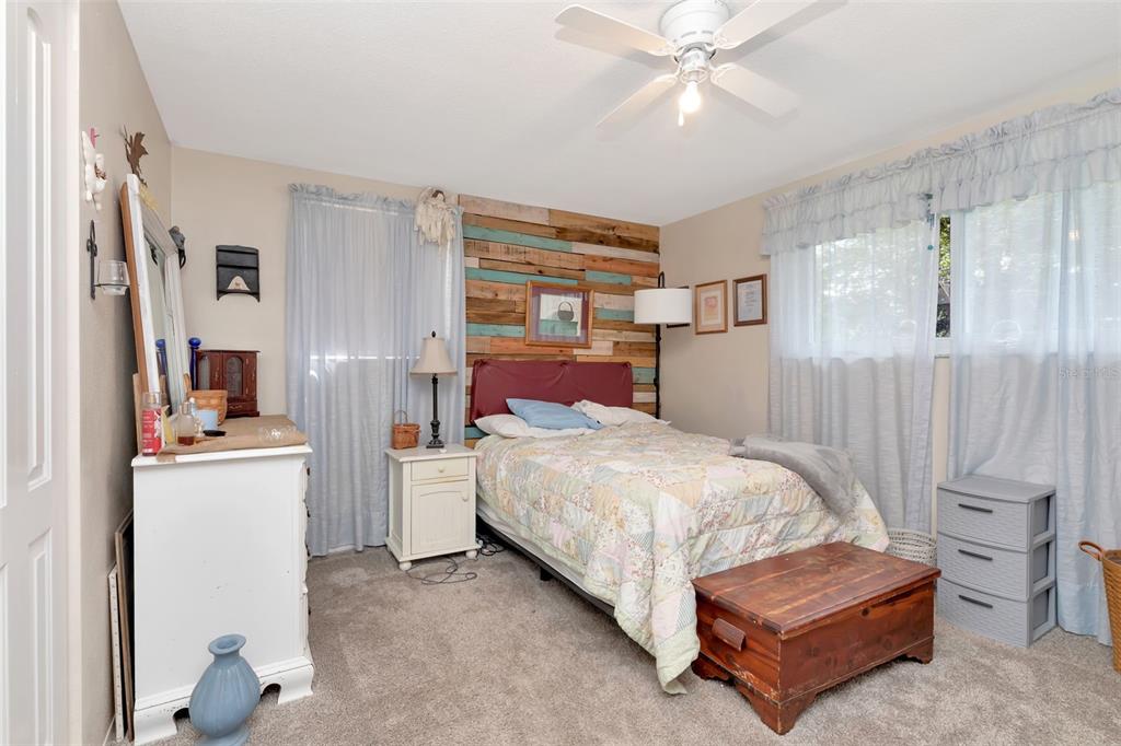 10301 Orchid Drive Port Richey, FL 34668 - Photo 31 of 35 a bedroom with a bed and a chandelier