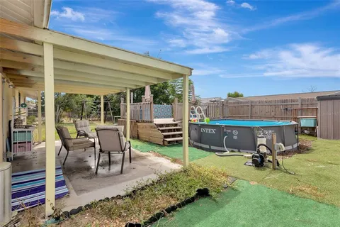a view of a patio with table and chairs near a barbeque