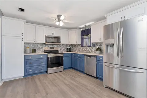 a kitchen with a refrigerator cabinets and wooden floor