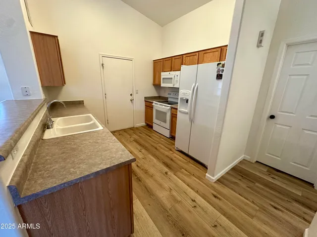 a view of kitchen with wooden floor and electronic appliances