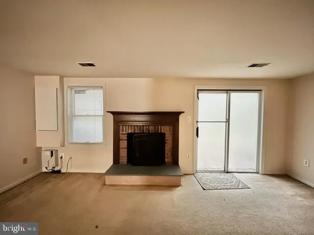 an empty room with windows and fireplace