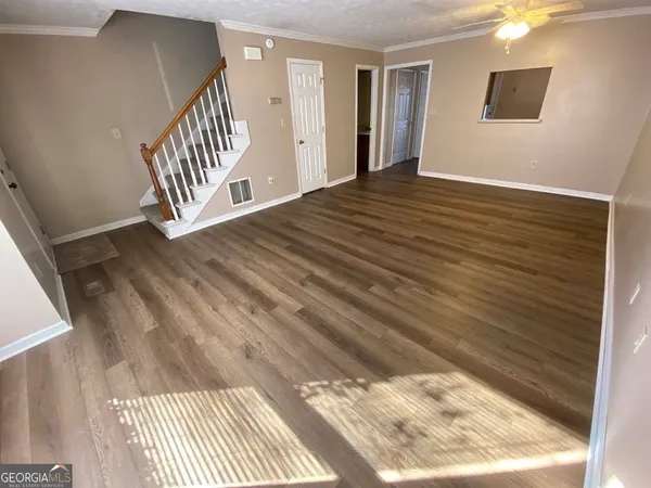 a view of a livingroom with wooden floor and stairs