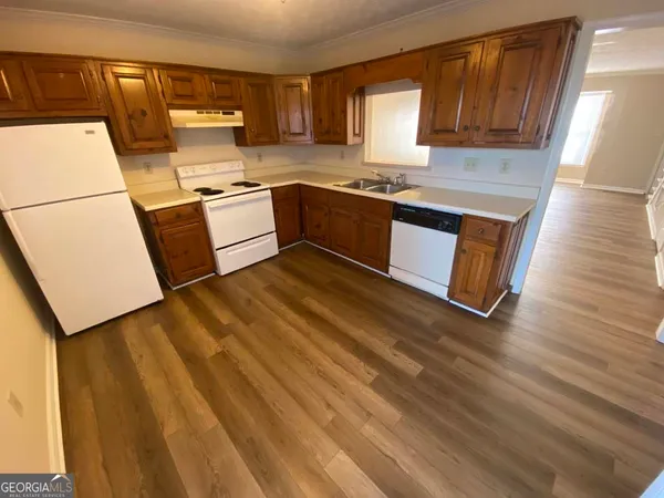a kitchen with stainless steel appliances granite countertop a sink a stove a refrigerator with grey cabinets and wooden floor