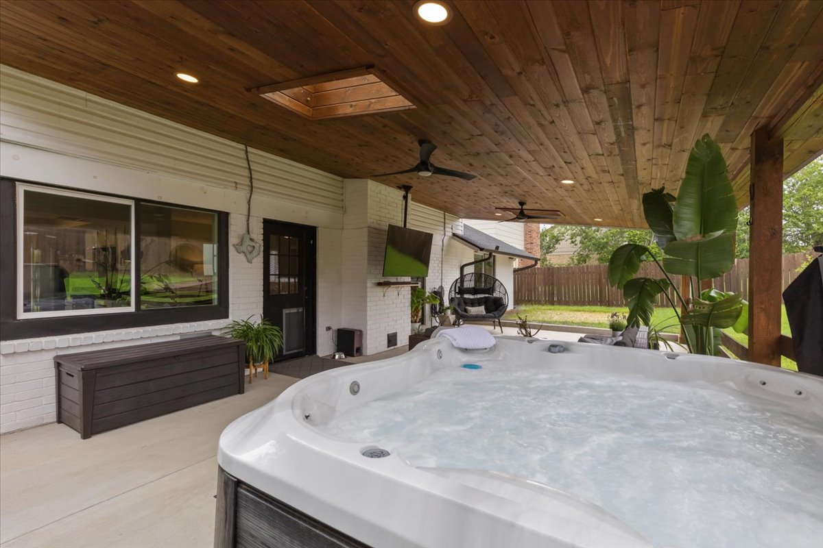 208 Skyloop Drive Austin, TX 78745 - Photo 3 of 34 Exceptional outdoor living space with oversized covered patio, hot tub, and custom wood ceiling.