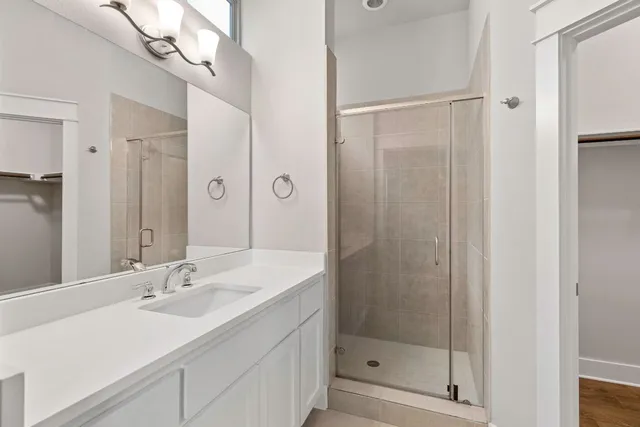 a bathroom with a shower sink and mirror
