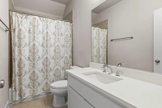 a bathroom with a sink a toilet and shower curtain
