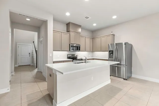 a kitchen with stainless steel appliances a sink stove and refrigerator